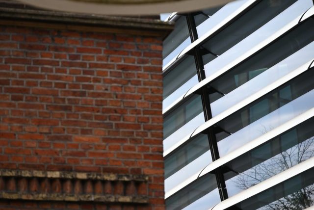 Photo of an old brick building meeting a modern glass and steel building in Enschede, the Netherlands