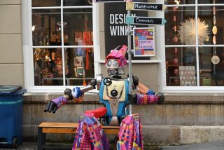 A colourful robot in front of a galery